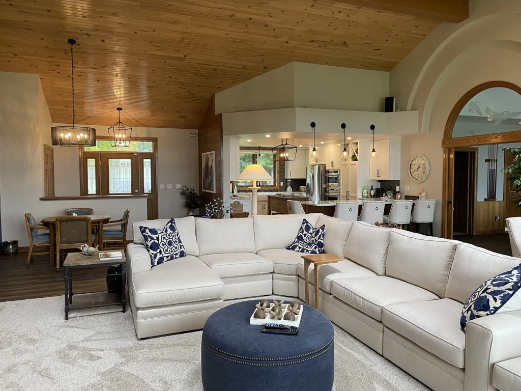 Elegantly decorated living room with unique lighting fixtures and a white sectional sofa with navy accents