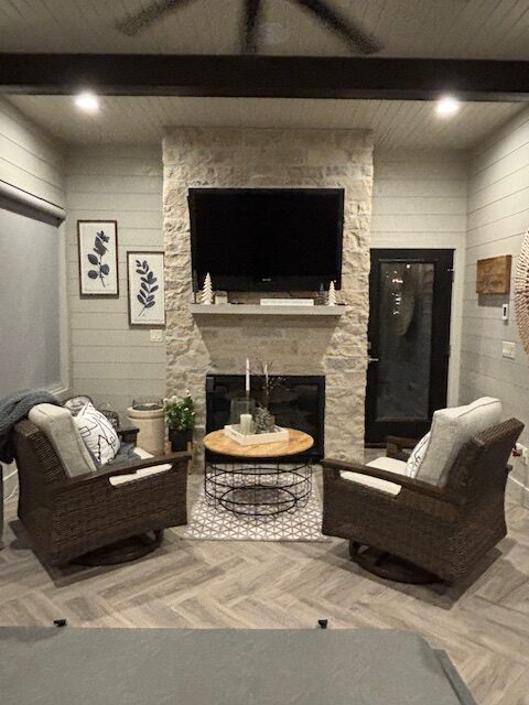 Light natural brick fireplace sitting room with two chairs and a coffee table interior decorating by Interiors of Distinction