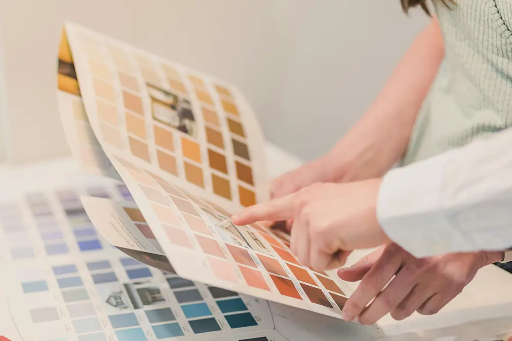 Interior designer looking at paint color swatches with a client